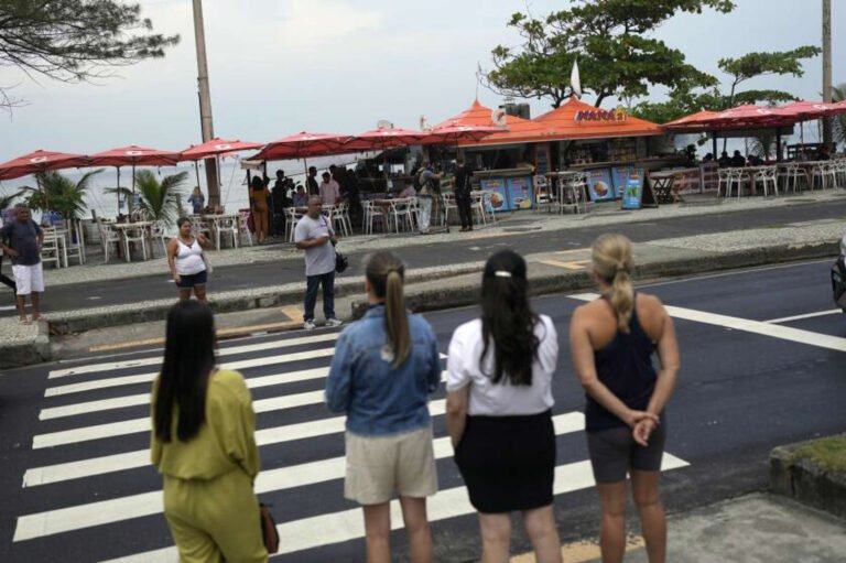 pedestrians gathered on the opposite side of the street from the "Nana 2" food and bar kiosk located on the beach in the Barra de Tijuca neighborhood of Rio de Janeiro, Brazil.