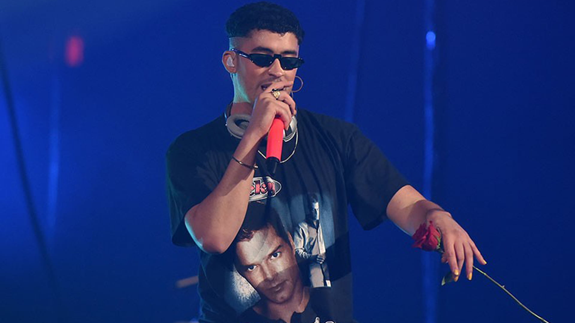 Bad Bunny's 2024 Tour: The Most Insane Show on Earth! Don't Miss This Wild Ride! 1 bad_bunny_with_headset_and_mike_is_wearing_black_dress_standing_in_blue_background_hd_bad_bunny